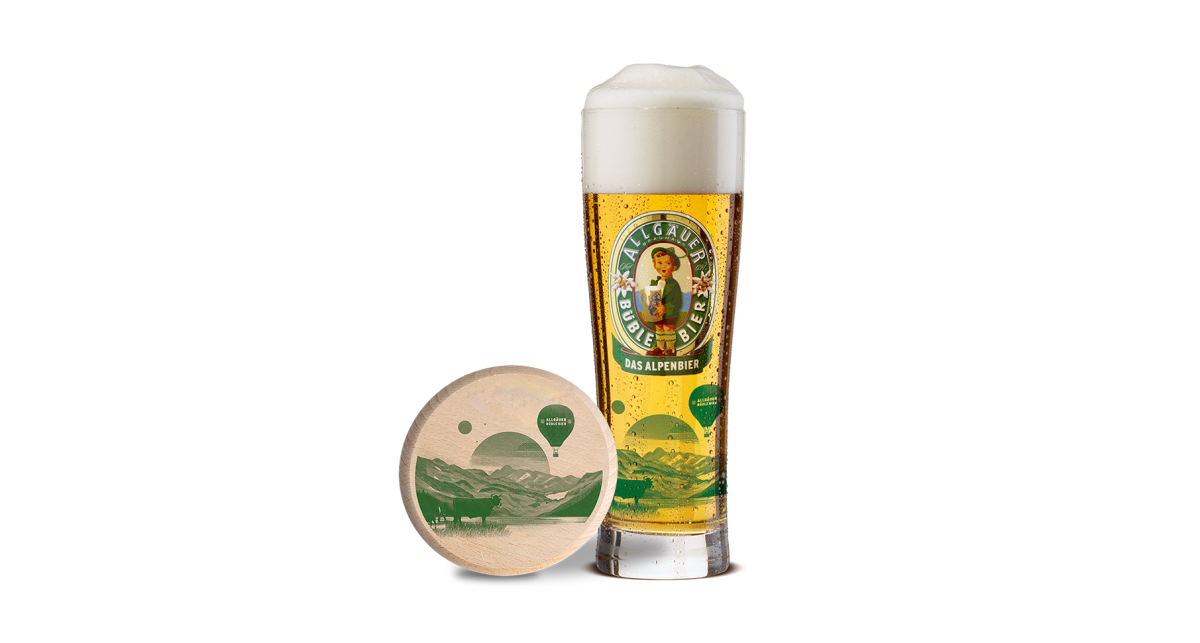 Ein betautes Allgäuer Büble Editionsglas, daneben eine Wespendeckel für Biergläser mit einer aufgedruckten Lanschaft.